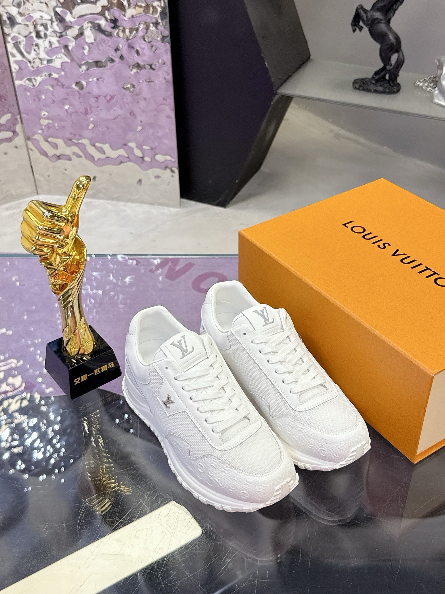 Louis Vuitton white sneakers on shoebox, side profile with V logo