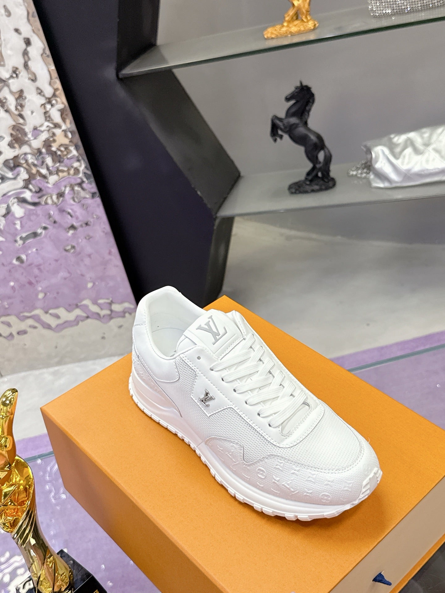 Louis Vuitton white sneaker on shoebox, angled view with lace-up