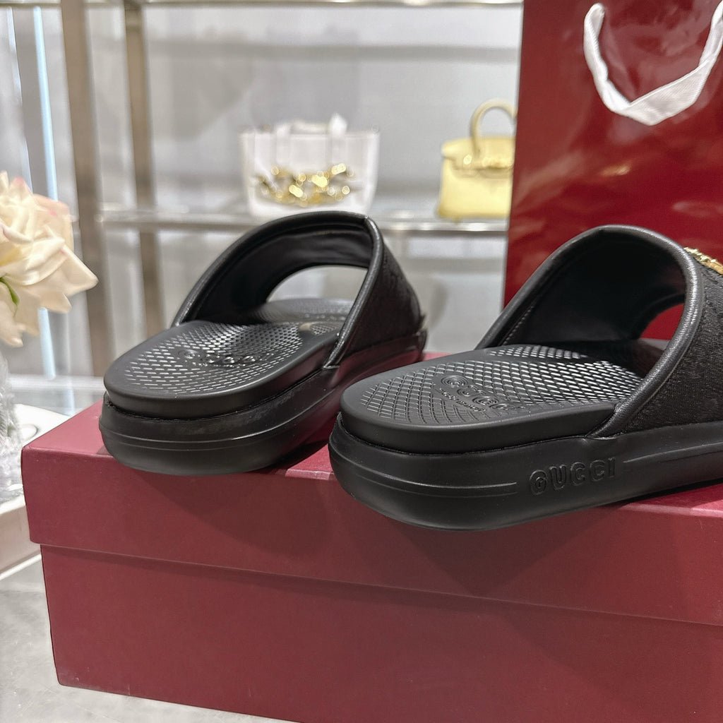 Black slide sandals with textured footbed and black sole, side view
