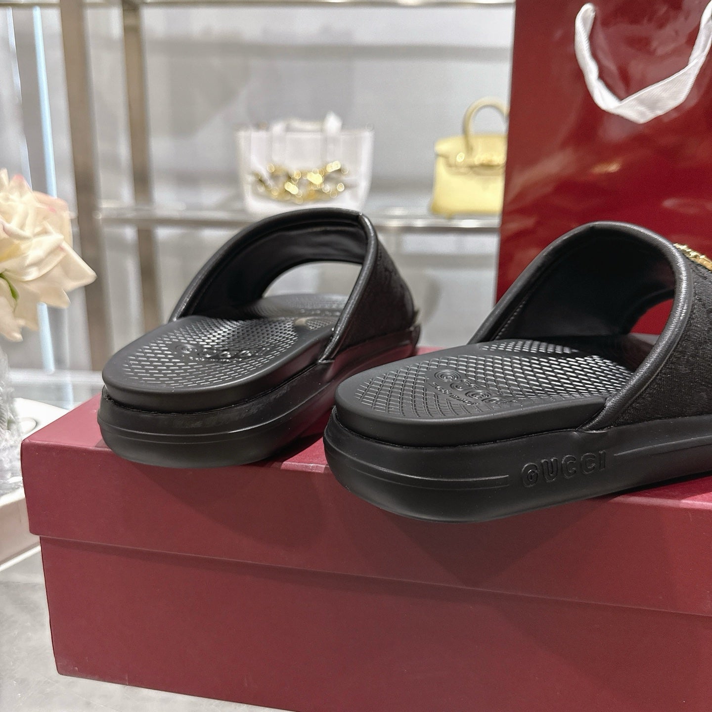Black slide sandals with textured footbed and black sole, side view
