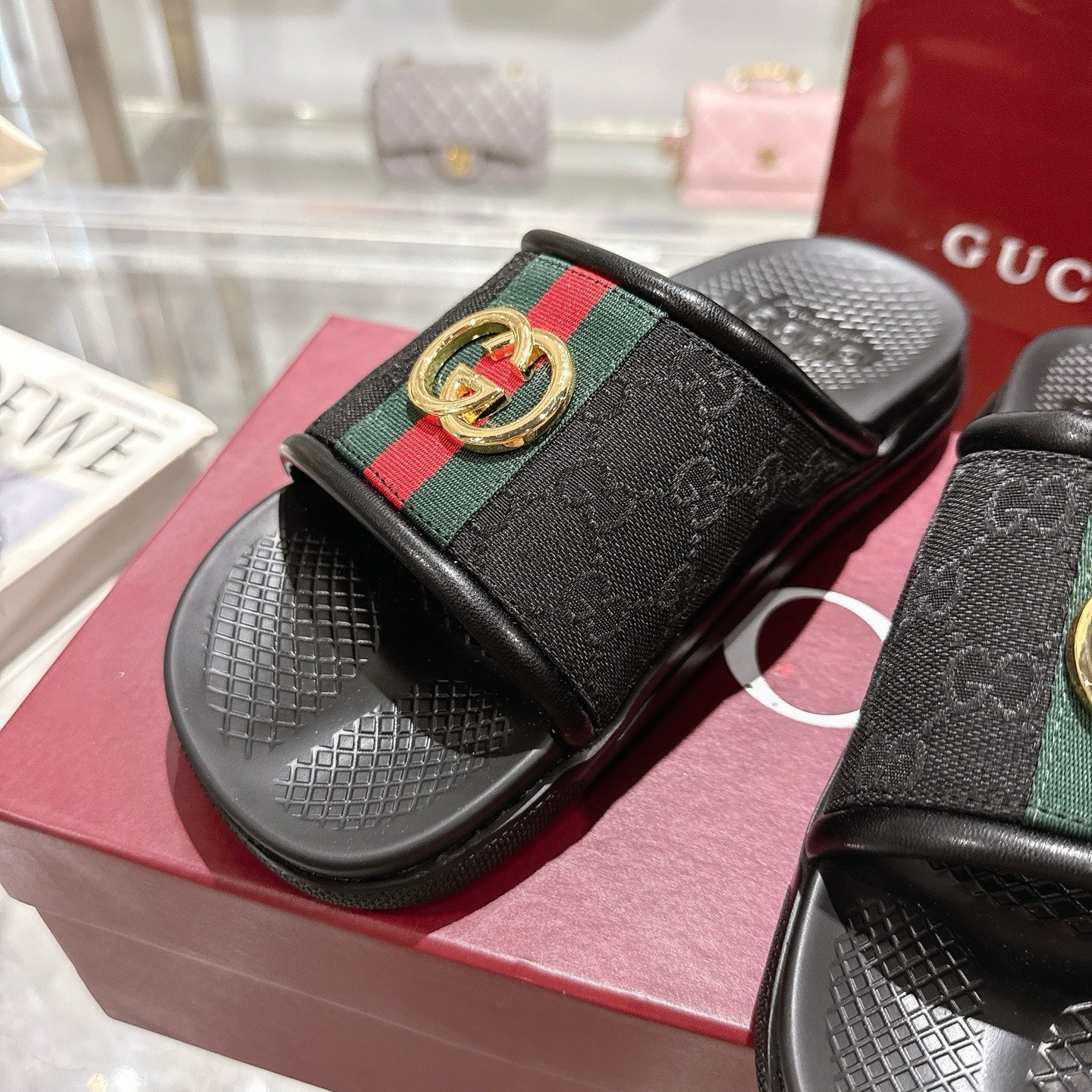 Black slide sandals close-up, green-red stripe strap with gold G buckle