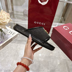 Black slide sandal sole side profile with green-red stripe strap and gold G buckle