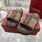 Gucci slide sandals with GG canvas straps, green/red web and gold-tone buckle, dark soles