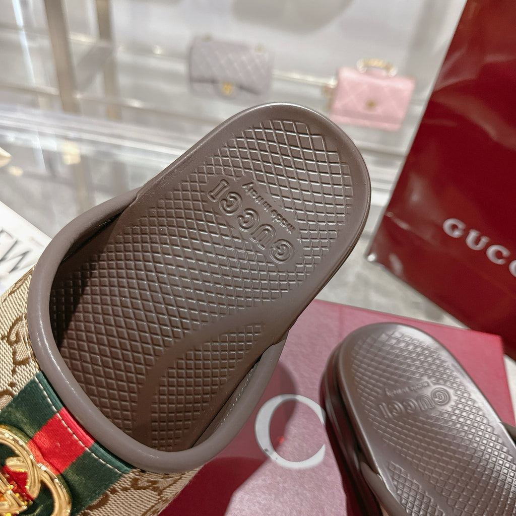 Gucci slide sandal outsole, dark brown textured tread with embossed GUCCI on footbed