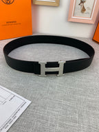 Black leather belt with silver-tone H buckle and metal keeper