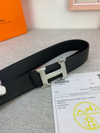 Black leather belt with silver-tone H buckle, textured strap detail