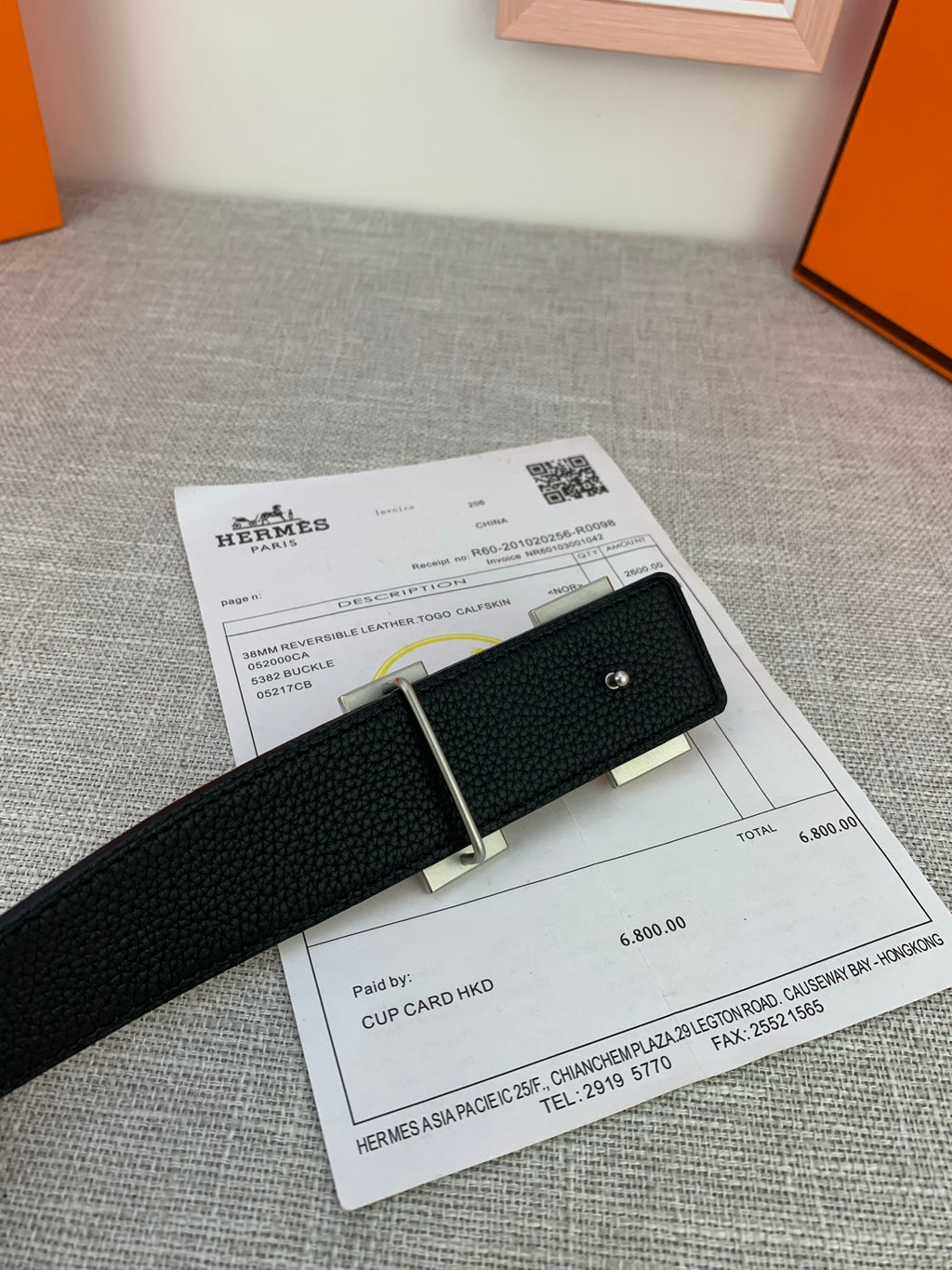 Black leather belt with silver-tone buckle and keeper on product paperwork