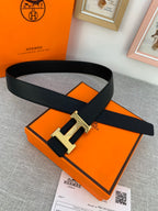 Black leather belt with textured strap and gold-tone H buckle