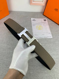 Reversible leather belt with light olive strap and black reverse side; silver-tone H buckle.