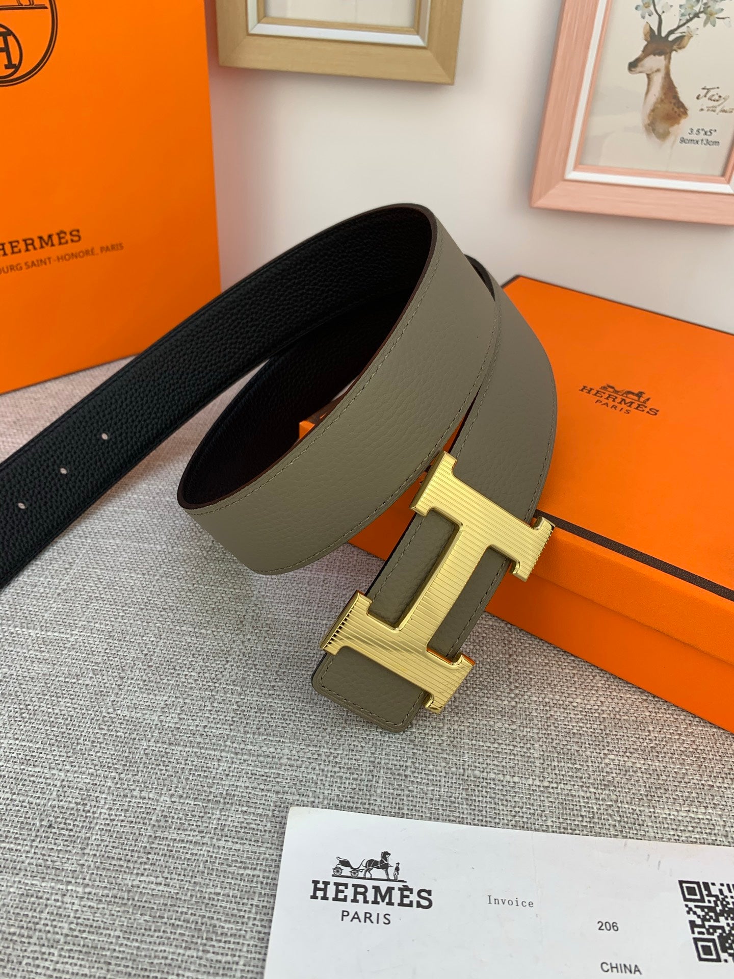 Reversible leather belt with dark leather underside and light olive face; gold-tone H buckle.