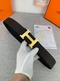 Hermes belt with dark leather strap and gold-toned H buckle detail, shown flat