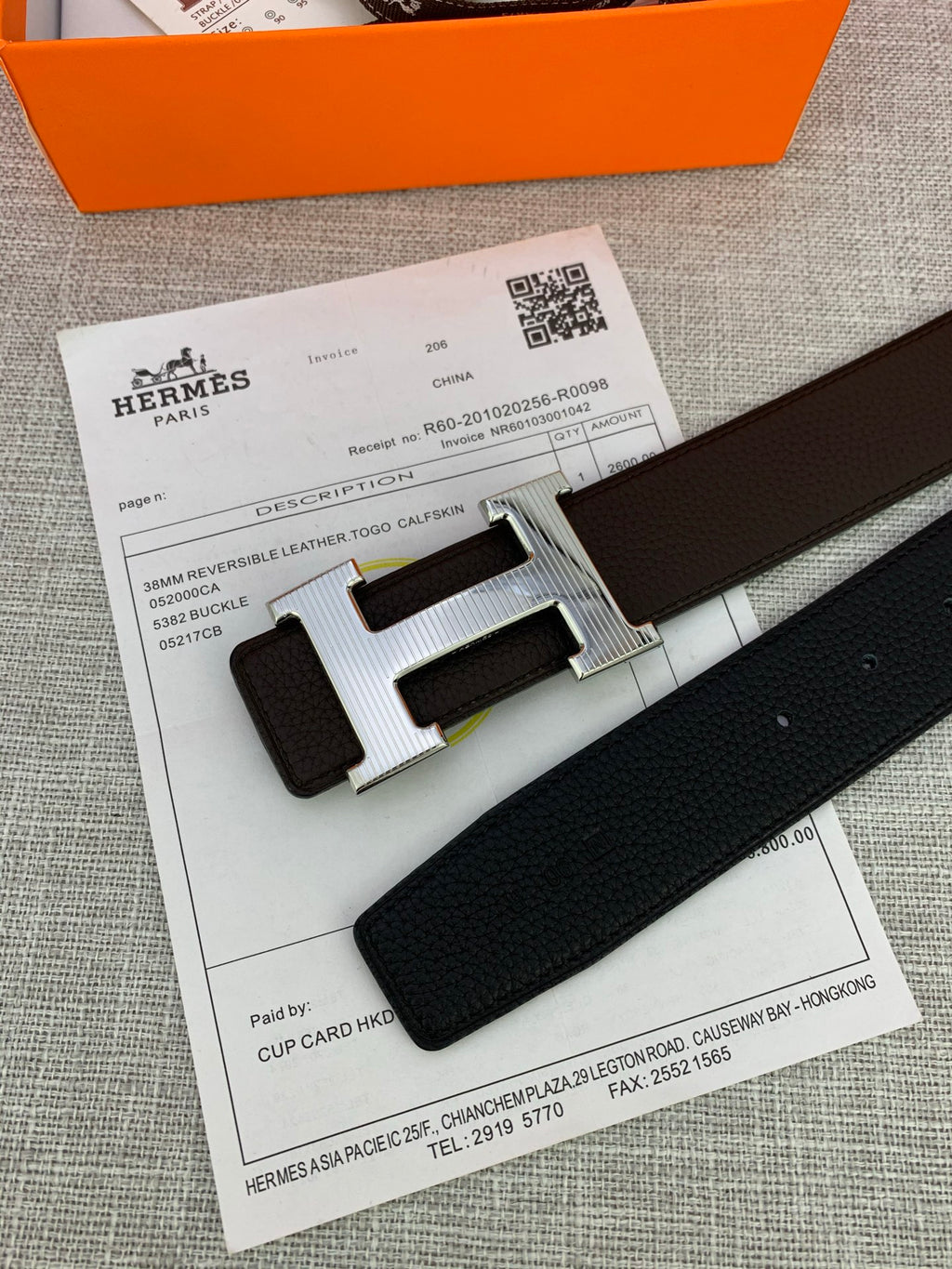 Hermes belt close-up on receipt: dark leather strap and silver-toned H buckle