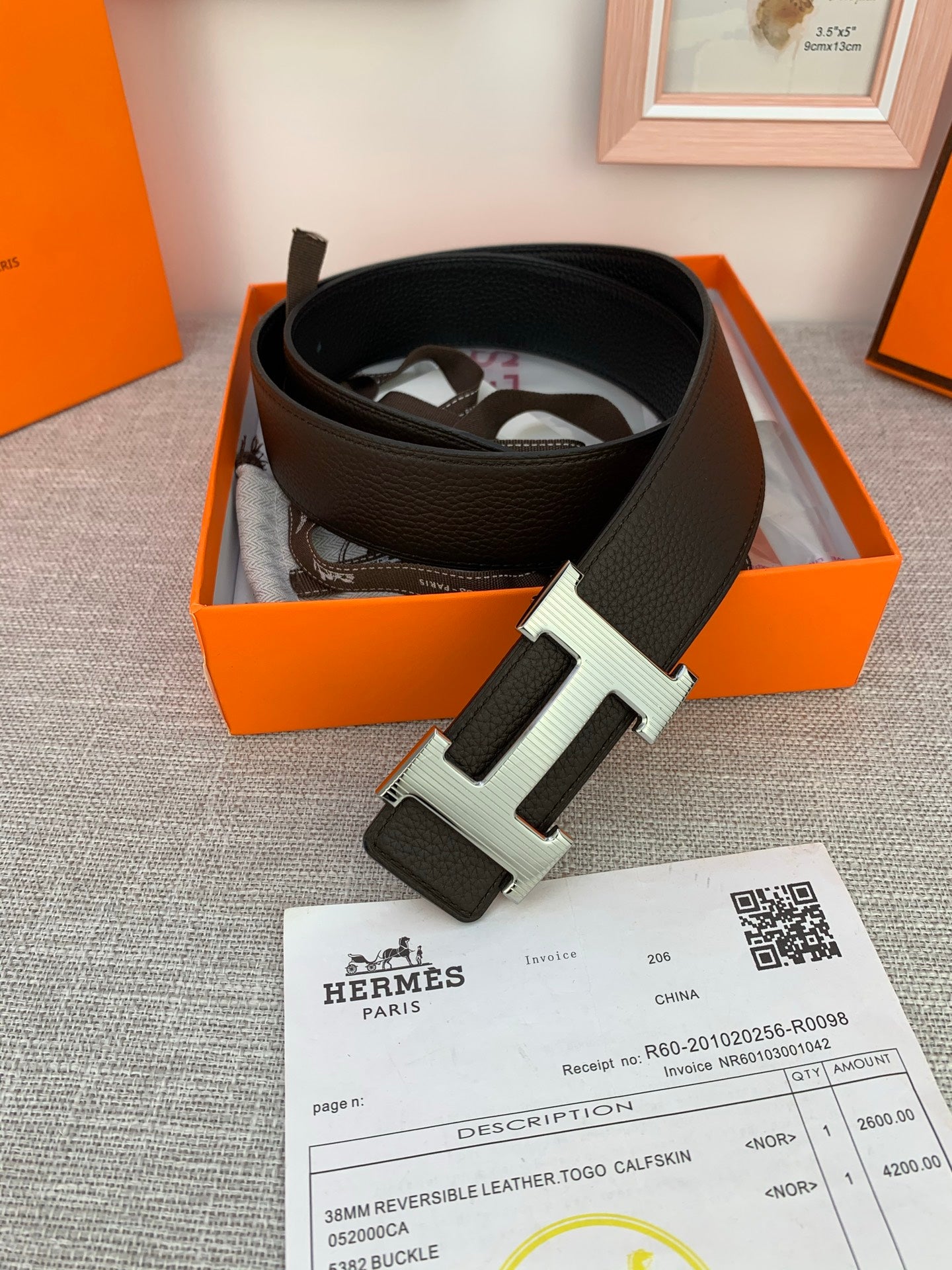 Hermes belt in orange box, dark leather belt with silver-toned buckle and label