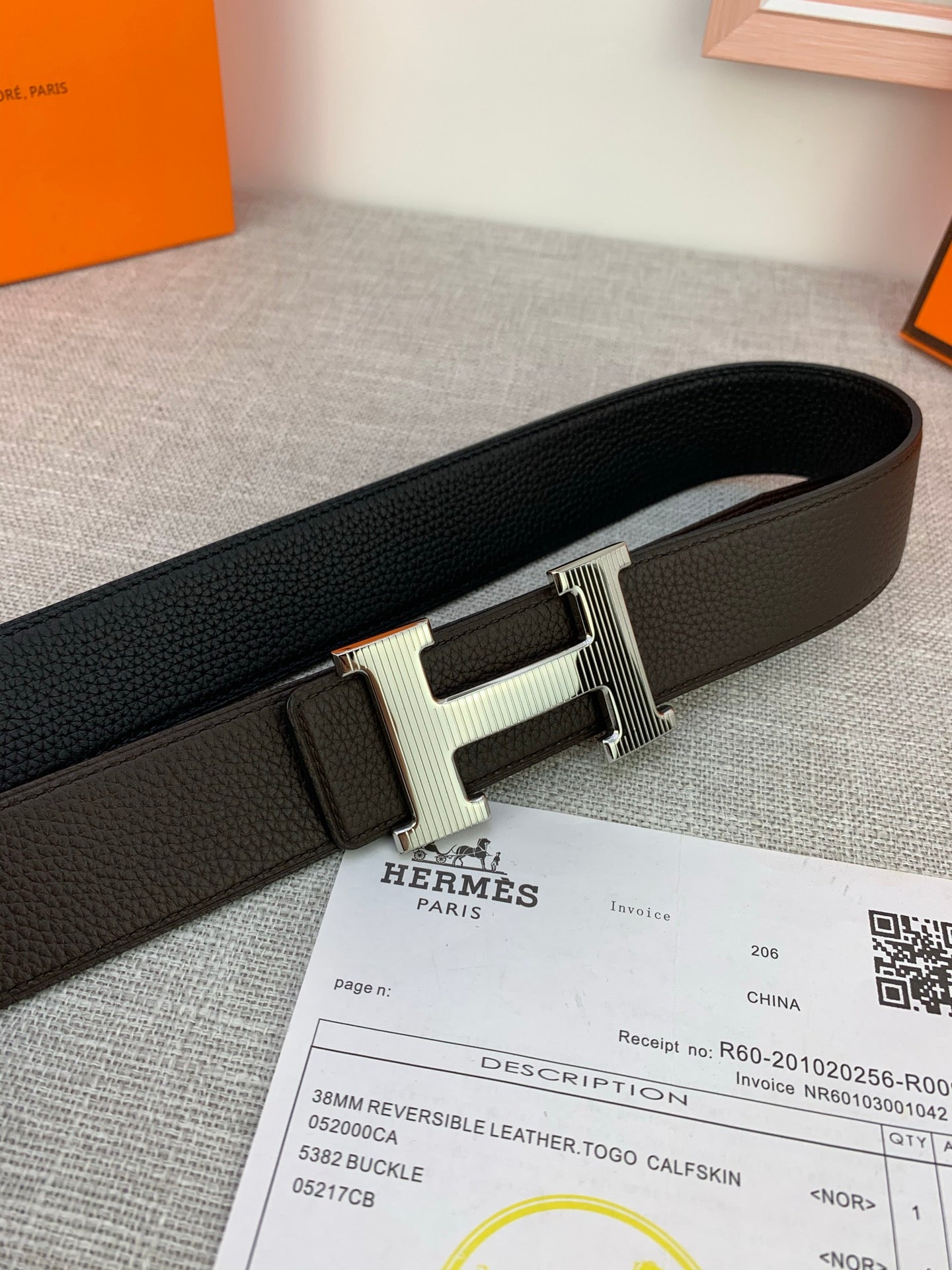 Hermes belt close-up: dark leather strap with silver-toned H buckle and keeper