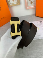 Hermes belt with gold-toned H buckle and dark leather strap, folded view