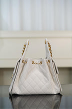 Chanel bag in white quilted leather with gold chain straps and side zipper pulls.