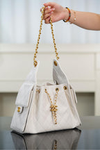Chanel bag in white quilted leather with gold chain handle, flap, and CC logo tab.