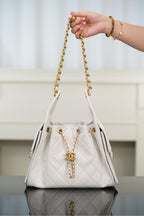 Chanel bag in white quilted leather with gold chain handle and CC pendant detail.