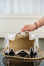 Chanel bag in white quilted leather with open top, gold chain trim, and fabric lining.