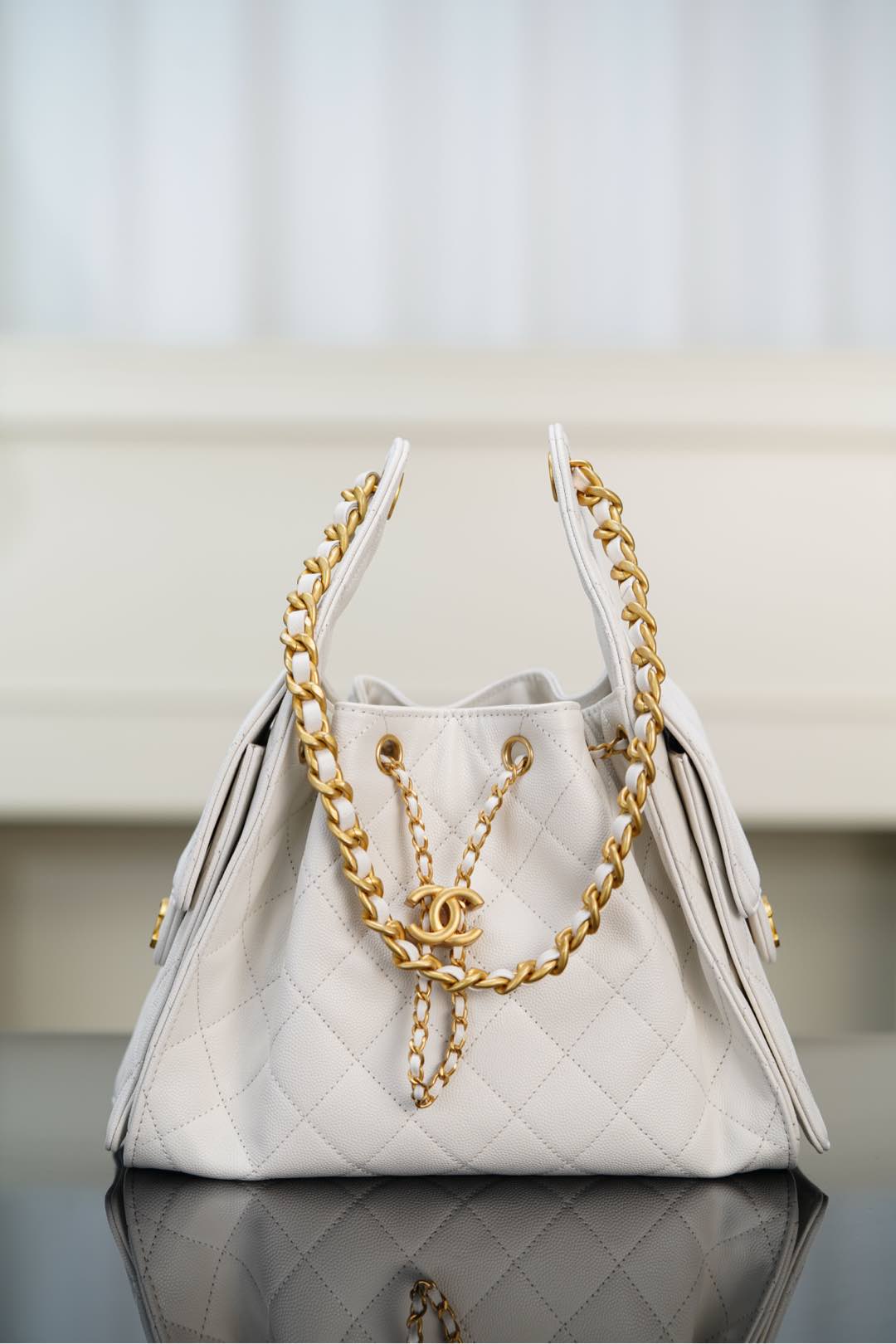 Chanel bag in white quilted leather with gold chain handles and CC clasp.