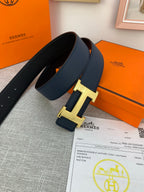 Hermes belt with navy leather strap and gold H buckle, photographed with paperwork