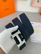 Hermes belt with navy leather strap and silver H buckle, close-up showing clasp