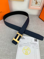 Hermes belt laid flat with navy leather strap and gold H buckle, with receipt