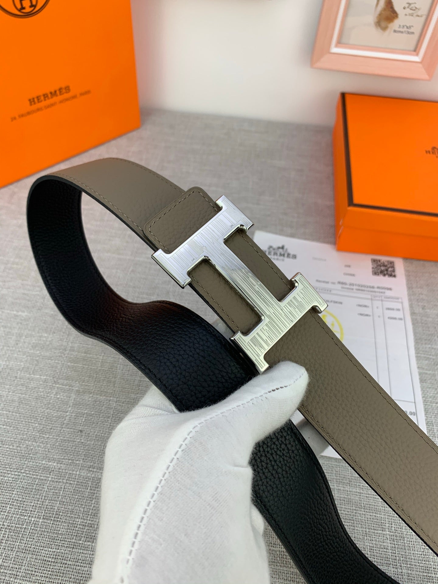 Reversible leather belt with olive outer side, black lining, and silver-tone H buckle