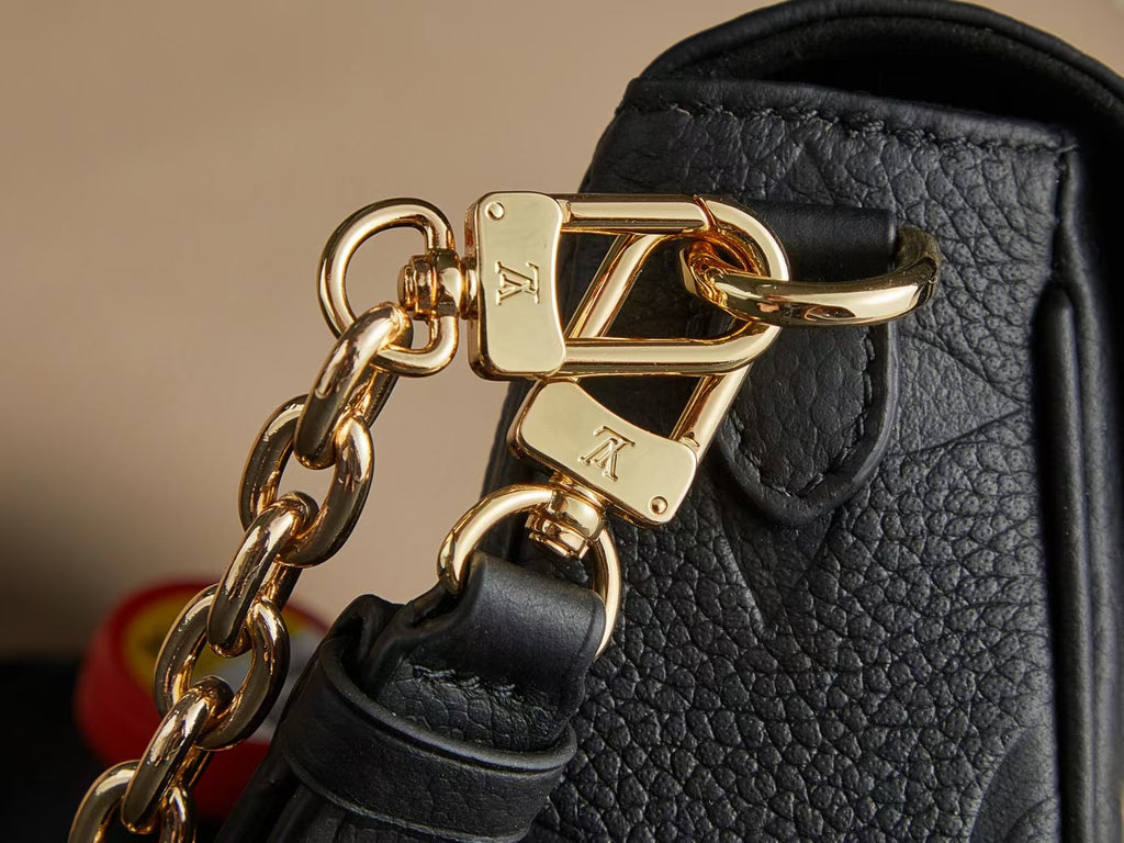 Louis Vuitton gold-tone chain clasp on black textured leather bag