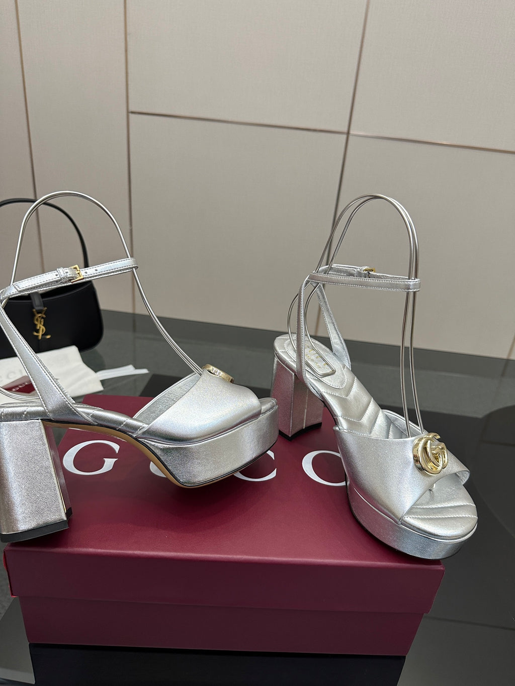 Silver slingback heeled sandals with gold logo buckle, open toe and block heel