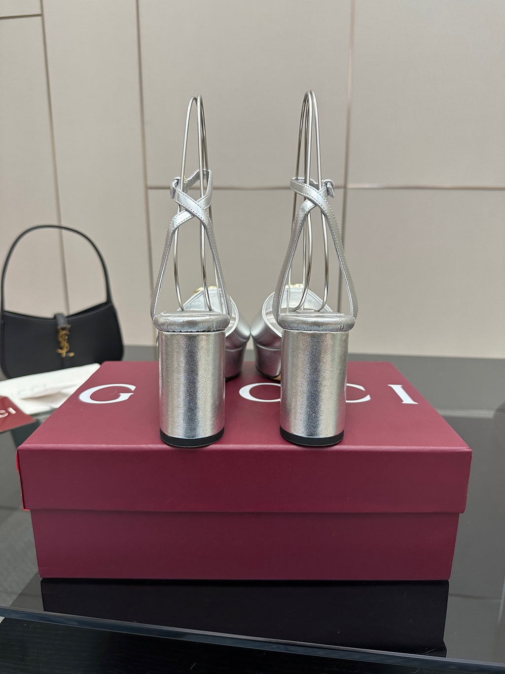 Silver platform heeled sandals with gold logo detail, open toe and tall cylindrical heels