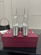 Silver platform heeled sandals with gold logo detail, open toe and tall cylindrical heels