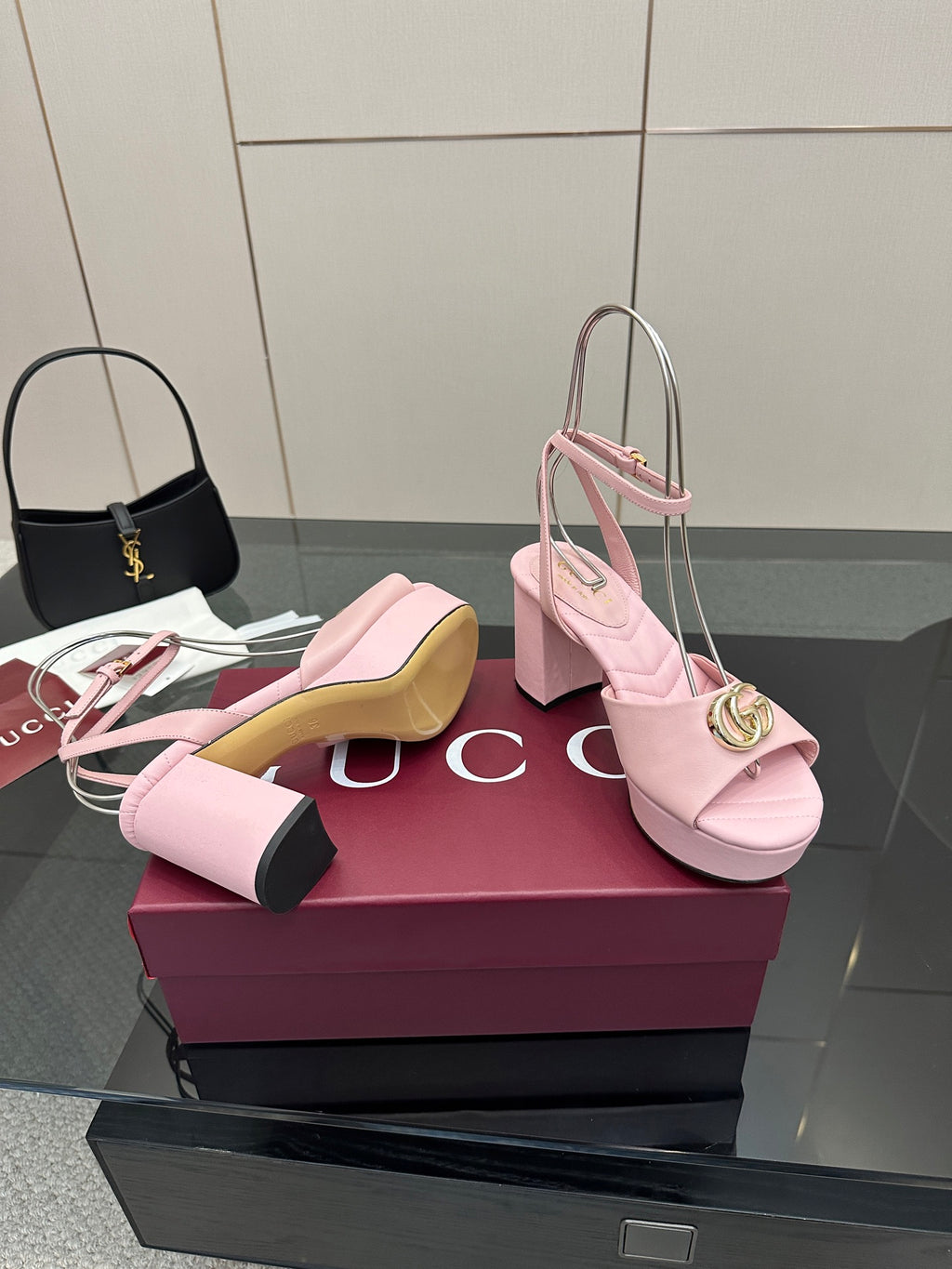 Pink heeled slingback sandals with open toe, thick heel, and gold logo buckle detail.