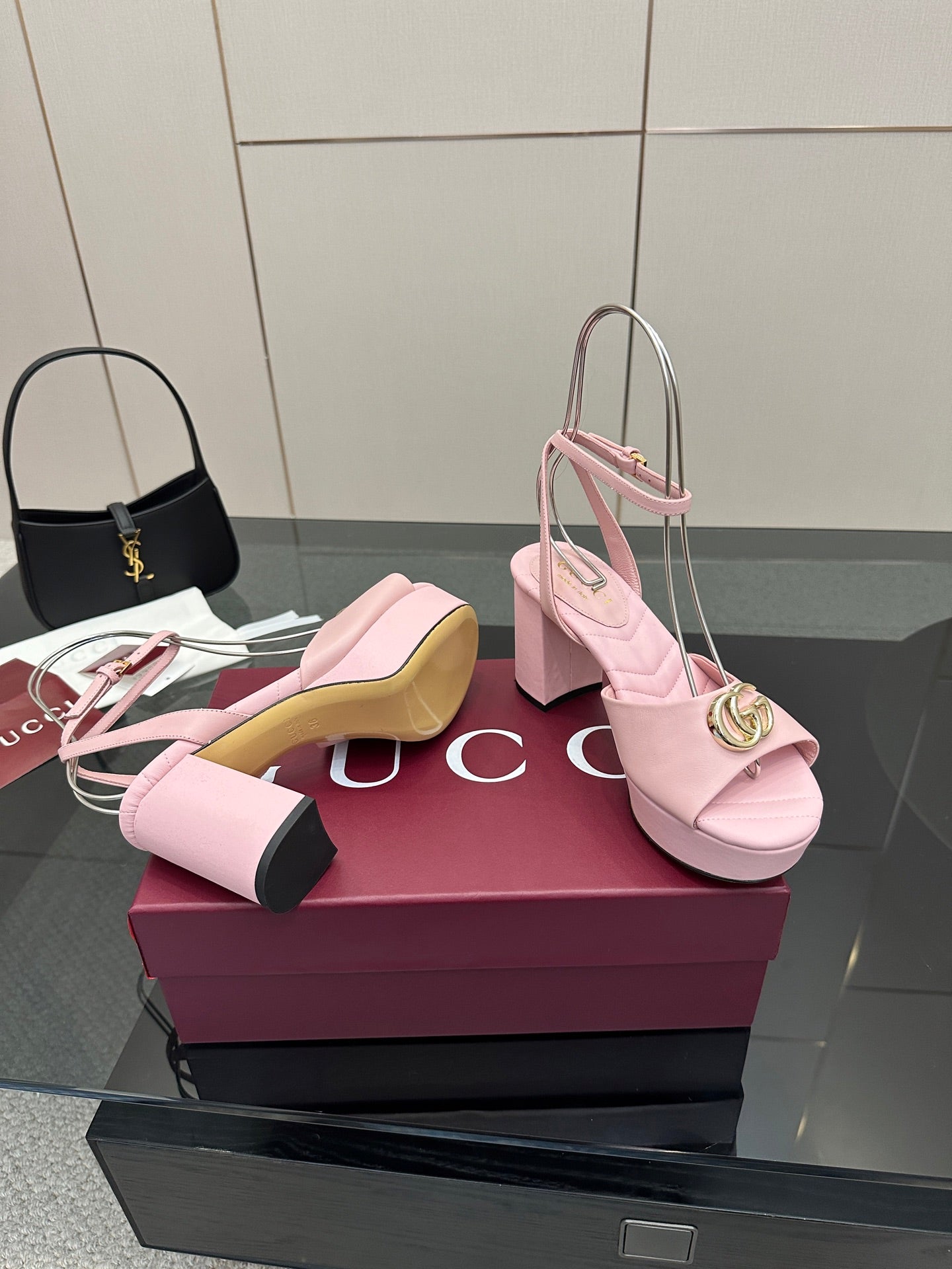 Pink heeled slingback sandals with open toe, thick heel, and gold logo buckle detail.
