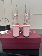 Pink open-toe platform sandals with tall stacked heel and gold logo buckle on strap.