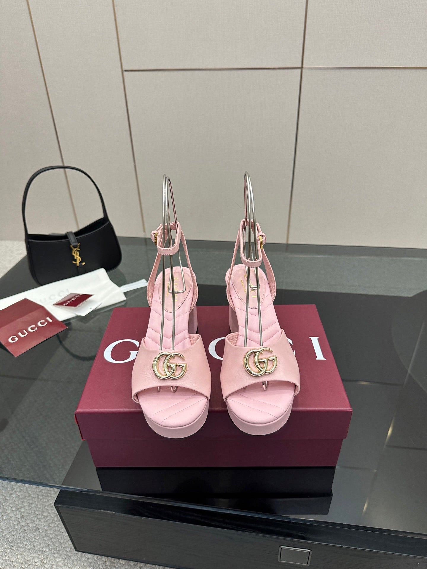 Pink heeled sandals with gold logo buckle and slingback ankle straps, open toe.