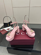 Pink heeled platform sandals featuring gold logo buckle on the slingback strap.
