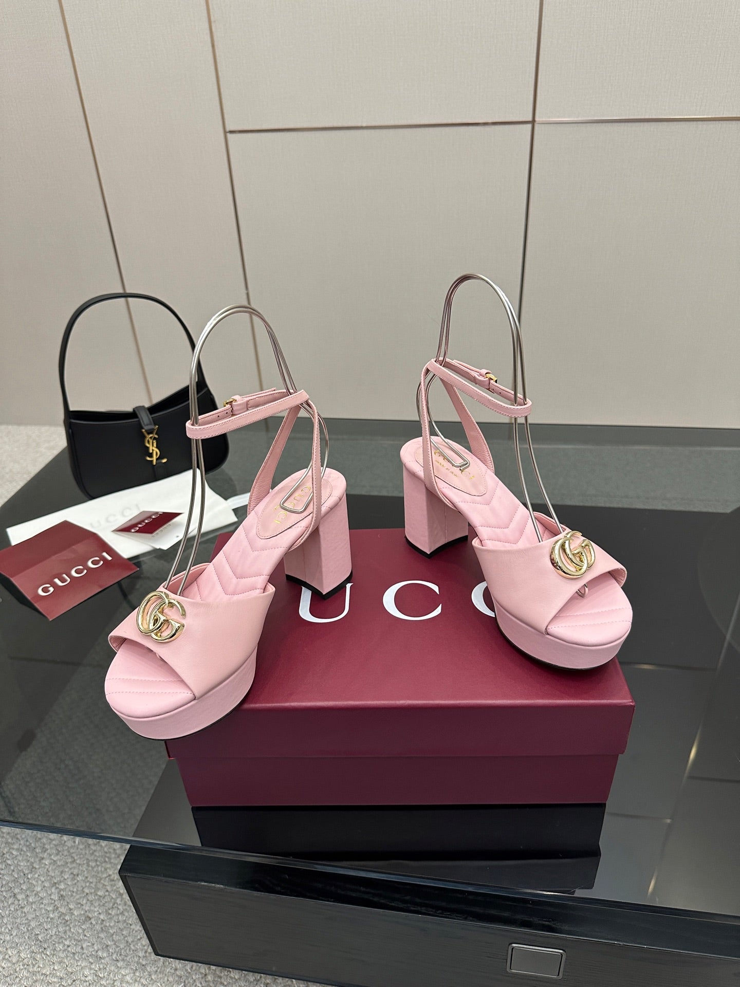 Pink heeled platform sandals featuring gold logo buckle on the slingback strap.