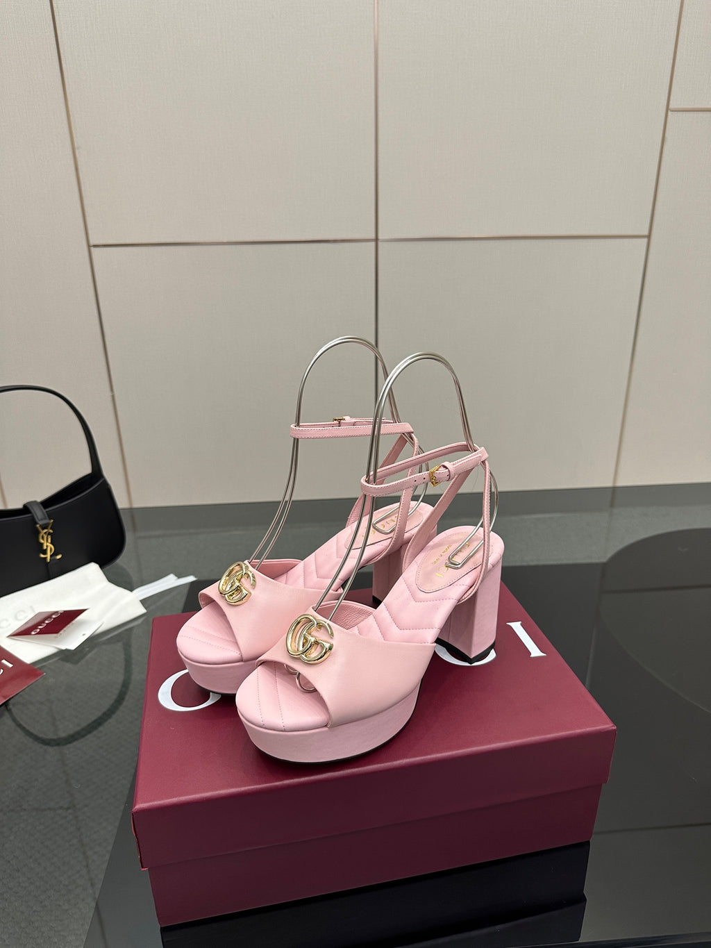 Pink heeled platform sandals with gold logo buckle, open toe and slingback strap.