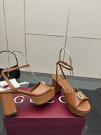 Tan platform heeled sandals with ankle strap and gold GG buckle, close side view