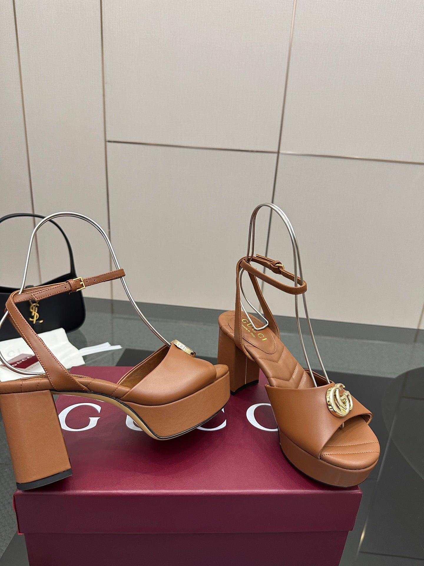 Tan platform heeled sandals with ankle strap and gold GG buckle, close side view