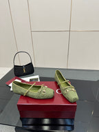 Pair of green patterned Gucci loafers on a red box, side view with horsebit detail