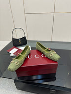 Green patterned Gucci loafers, angled view showing gold horsebit and bow detail