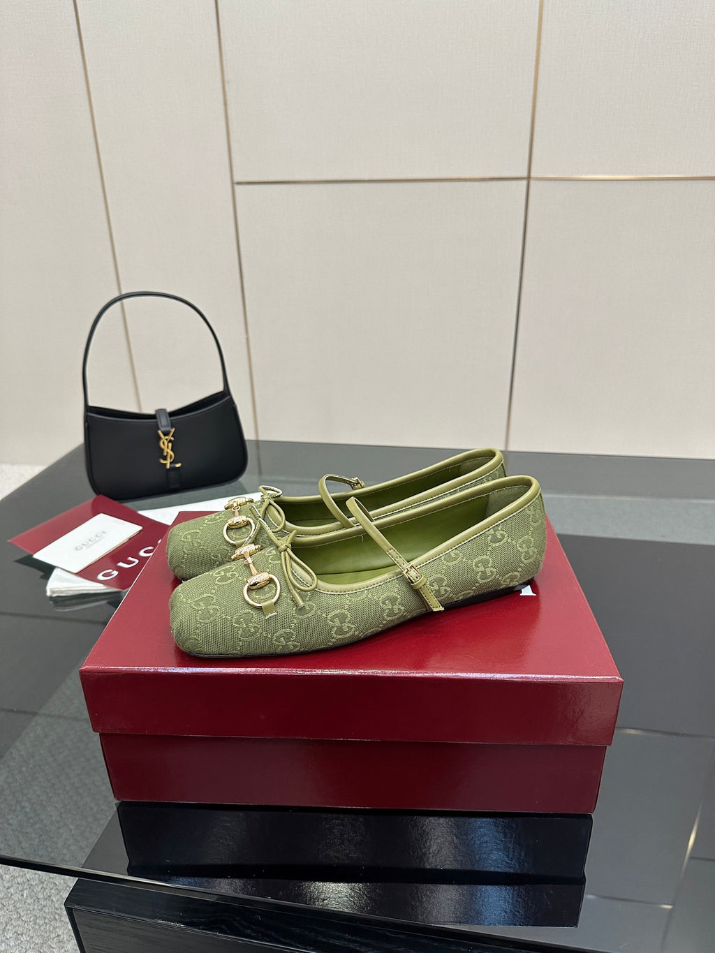 Green patterned Gucci loafer on a red box, front profile with gold-toned horsebit