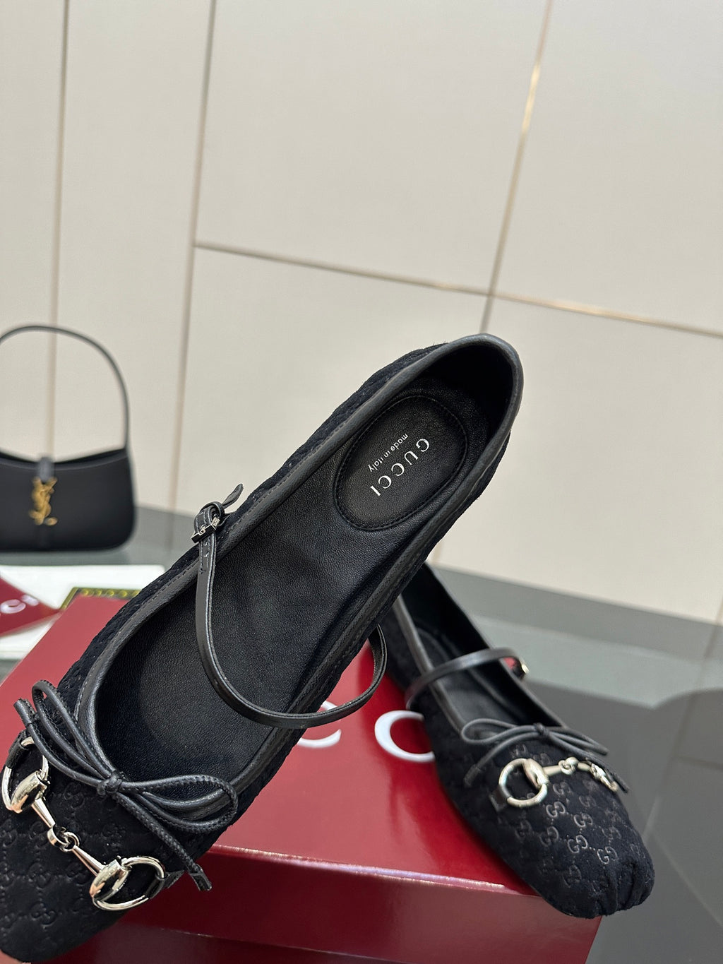 Gucci black flat loafer pair, side view with metal chain hardware and patterned upper