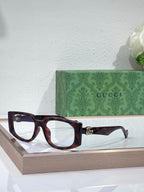 Gucci glasses with dark tortoiseshell frames and clear lenses