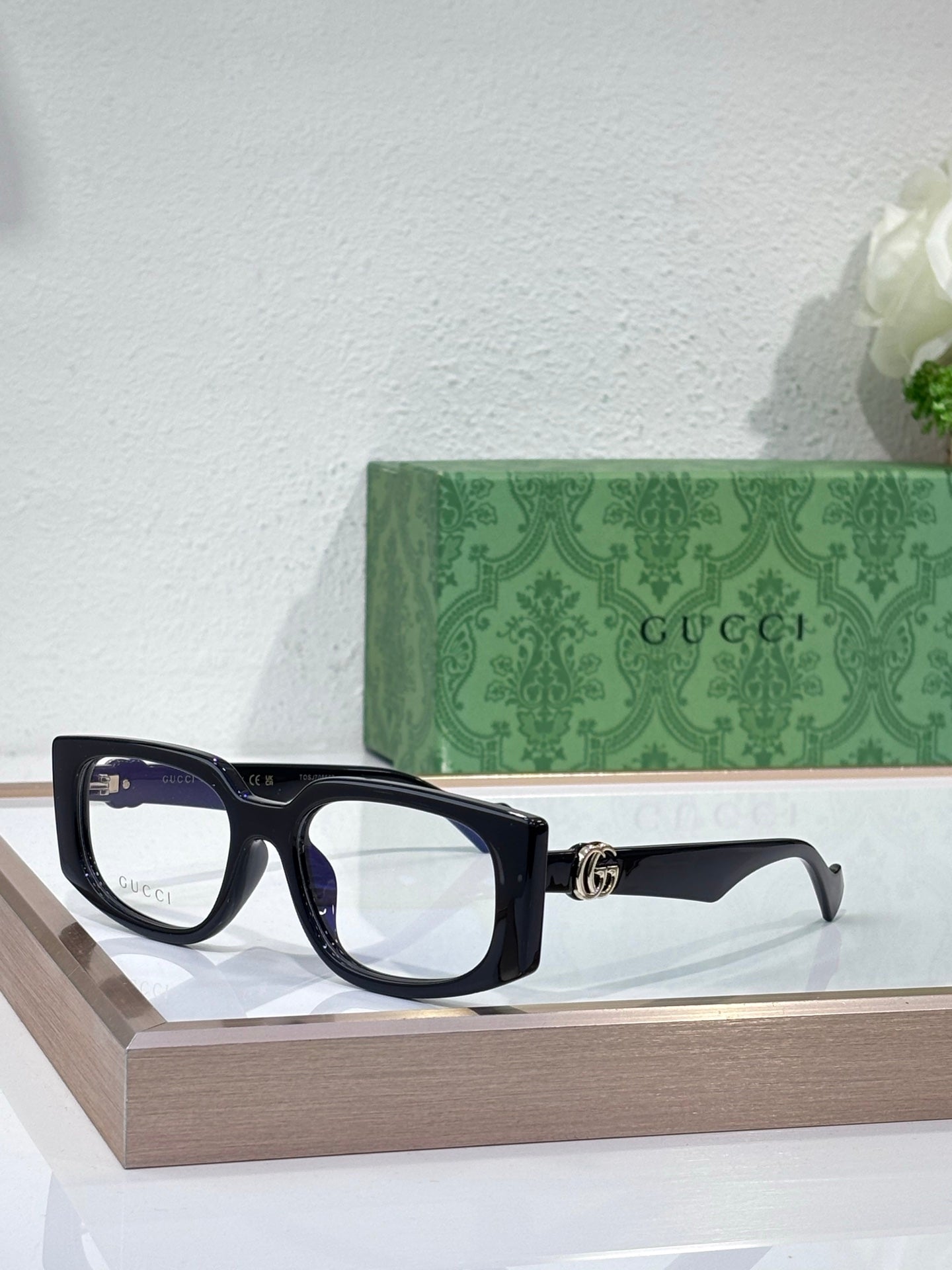 Gucci glasses with dark navy rectangular frames and clear lenses