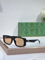Gucci glasses with dark navy frames and tan-tinted lenses