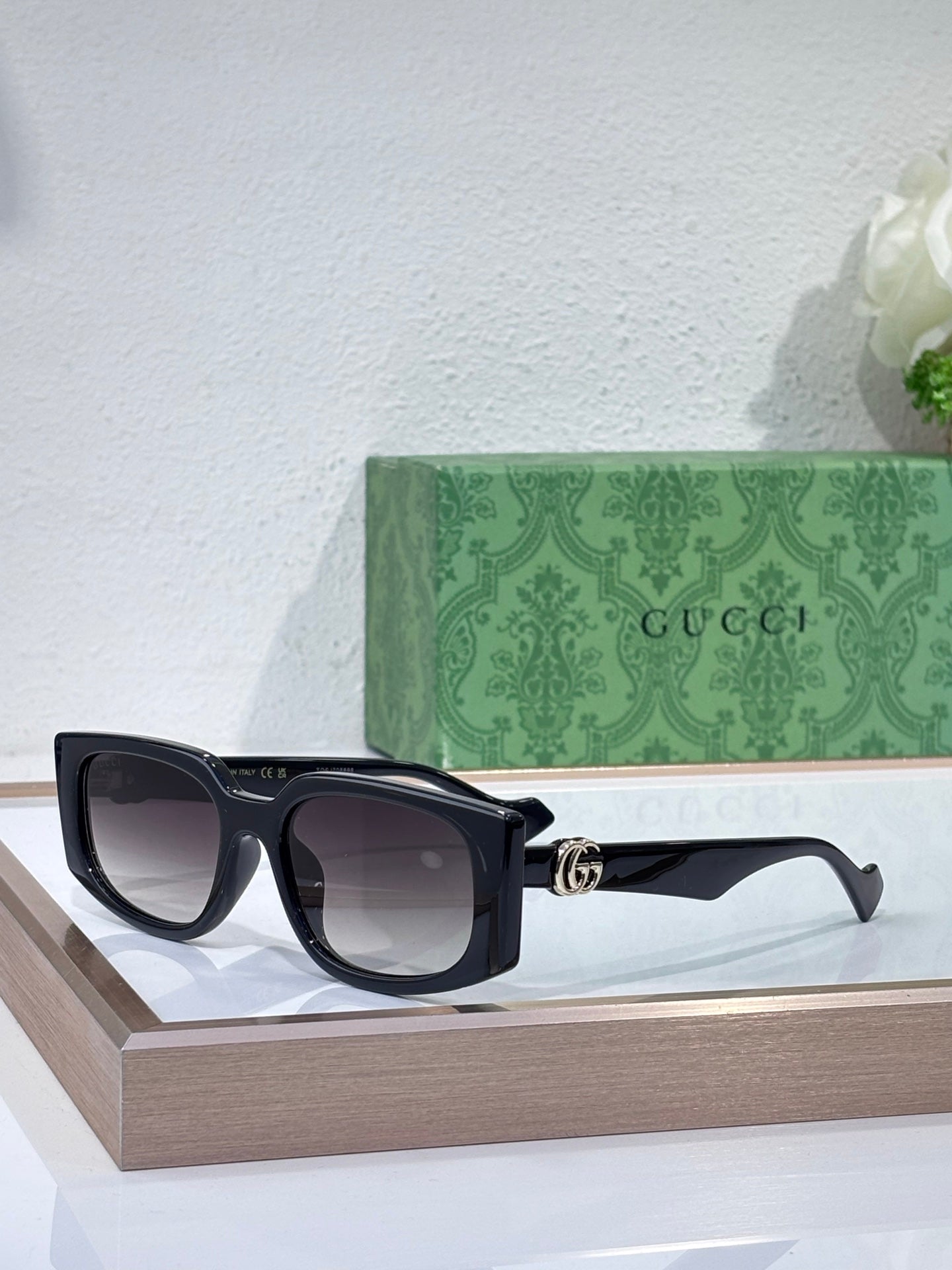 Gucci glasses with black square frames and dark tinted lenses