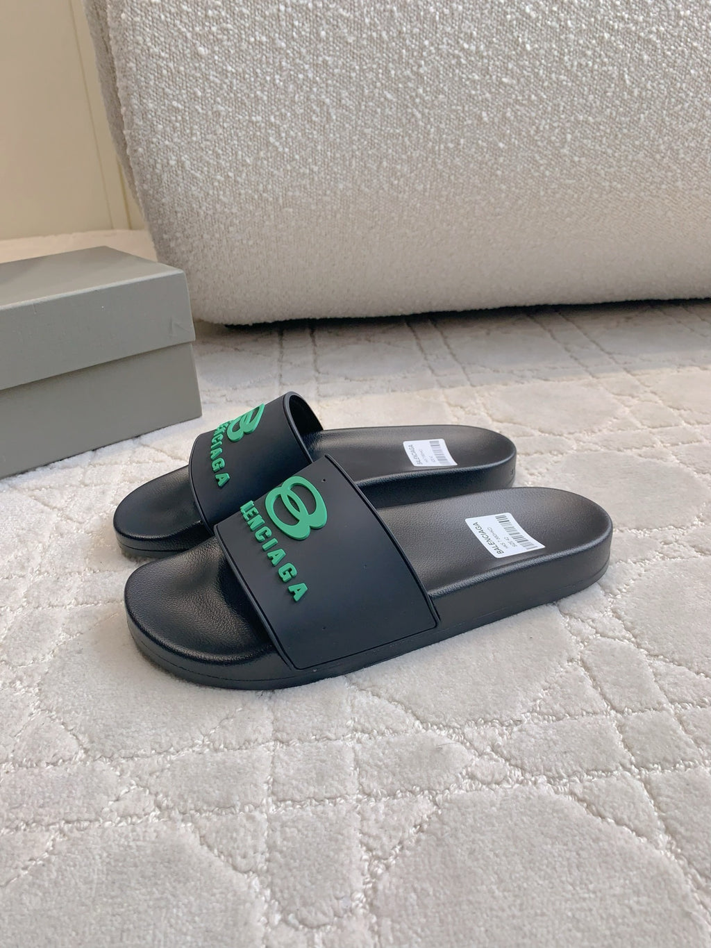 Black Balenciaga slide sandals with green logo strap, side view